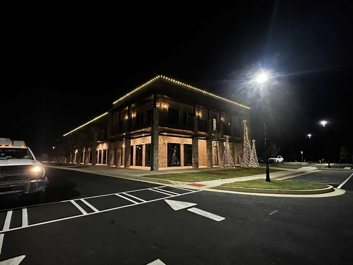 Commercial building with warm white Christmas lights and lighted trees