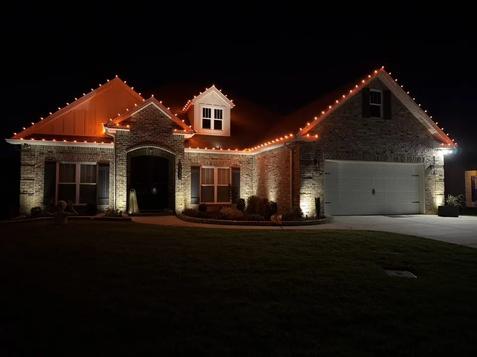 Brick home with red Christmas roofline lights