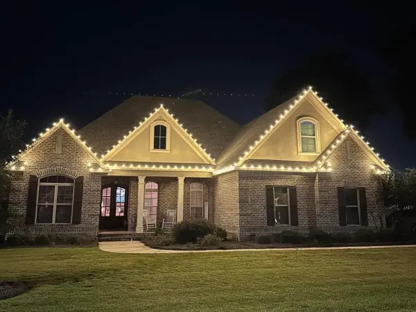 Brick home with warm white lights along every roofline